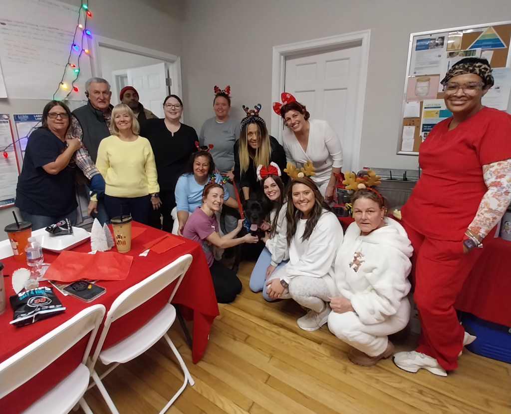A group of people poses together at Heart of Georgia Animal Care after a holiday performance by Beverly V Hill of the Park Avenue Opera